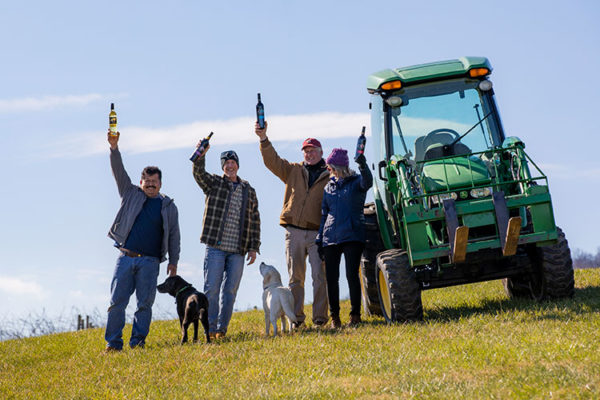 Team of the Virginia Wine Club for October One Vineyard standing by tractor in vineyard