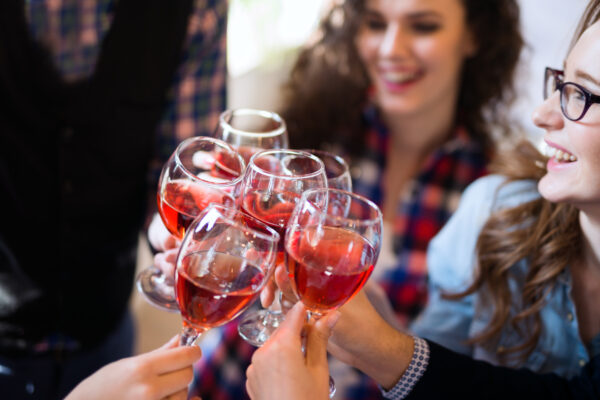 Cheers, wine glasses together with girl in background